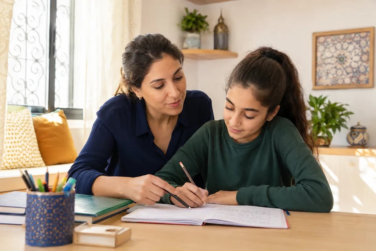 Une enseignante accompagne une élève pendant un exercice scolaire